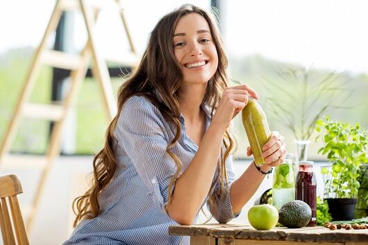 Girl drinks green smoothie for weight loss